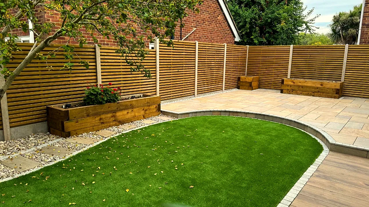 Back garden transformation with sandstone patio, lawn and timber slatted fence in Twickenham