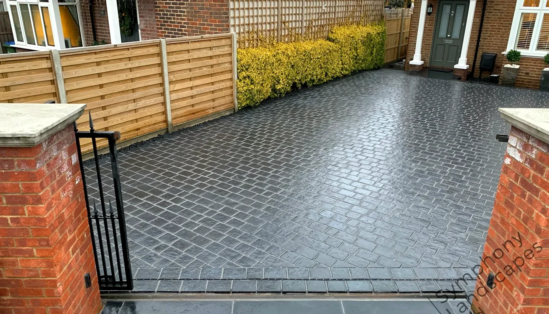 Grey block paved driveway with brick pillars