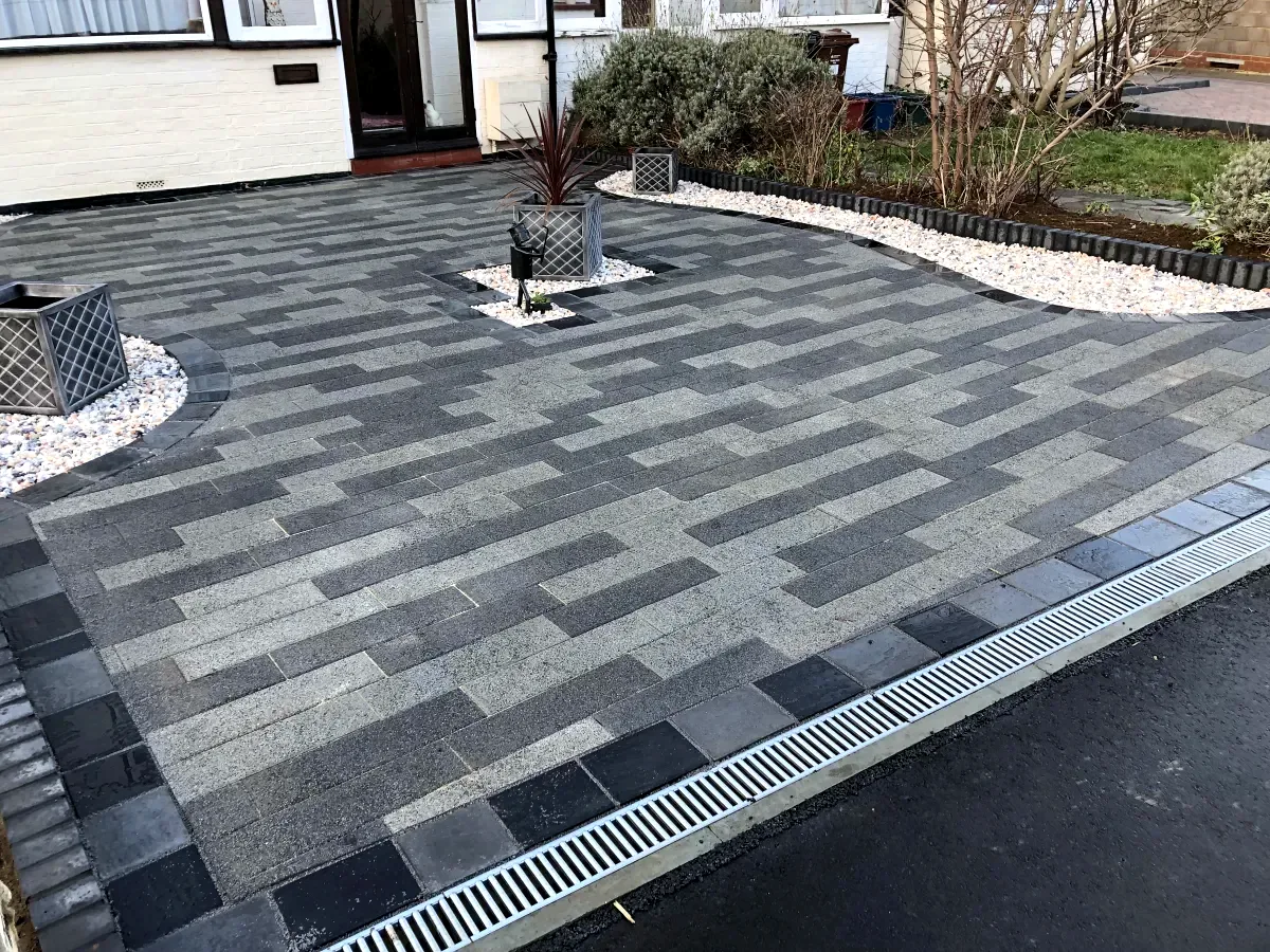 Dark grey block paving driveway with planters