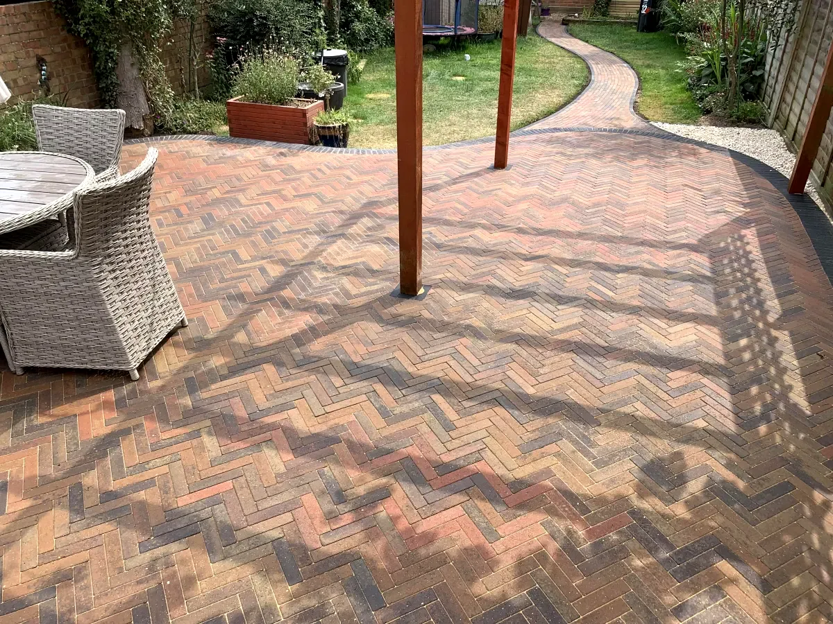 Brick herringbone patio with curved path to garden