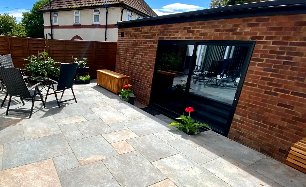 Slate grey patio beside brick garden building