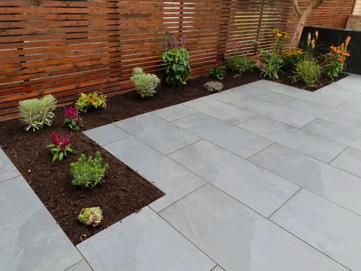 Slate grey patio with cedar fence and planting