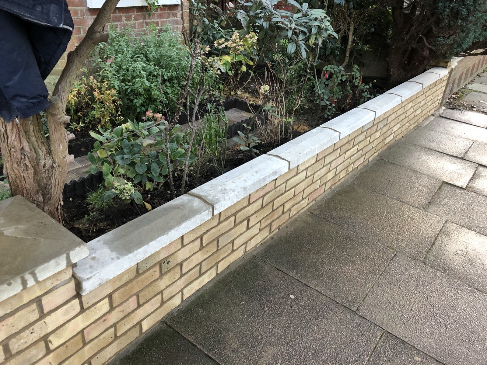 Yellow brick garden wall with sandstone coping in Twickenham